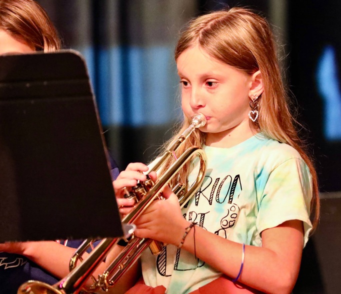 Students play musical instruments at the assembly