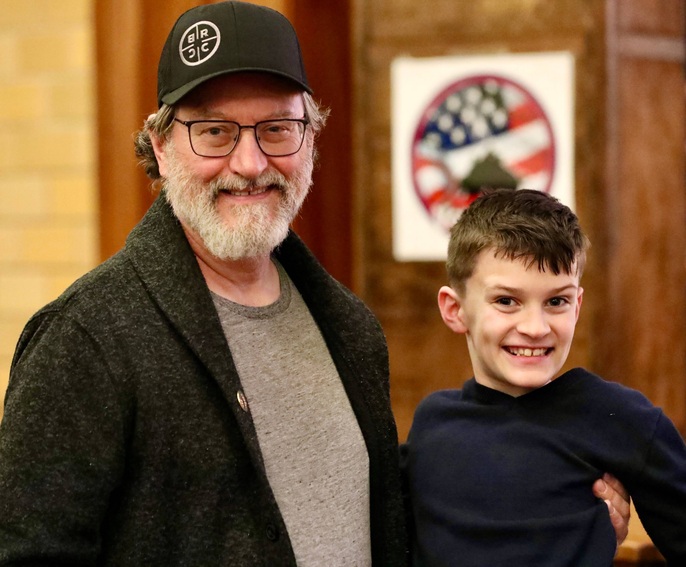 A veteran poses with a student after the ceremony