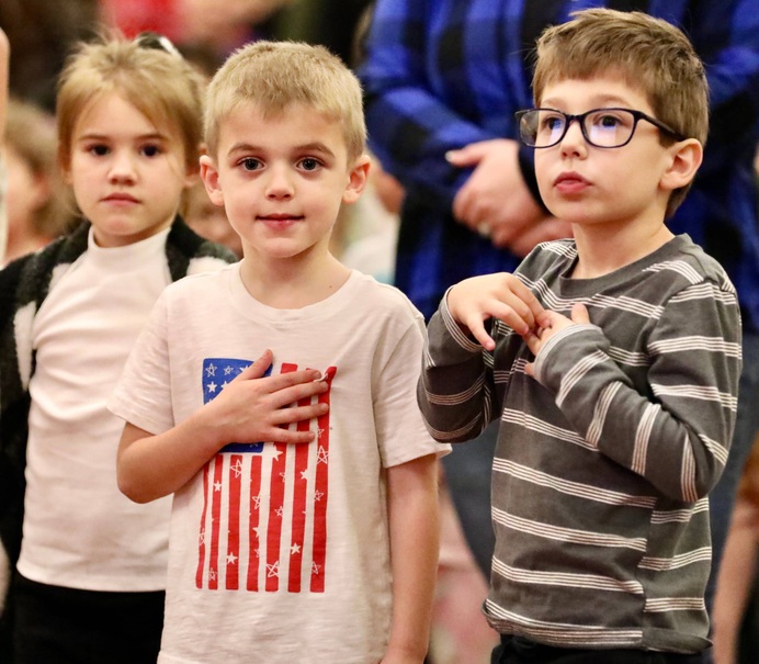 Students stand during the ceremony