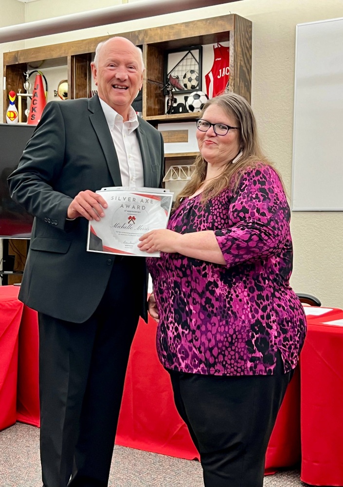 Picture of Michelle Morris receiving Silver Axe Award from Board President, Jay Wyatt