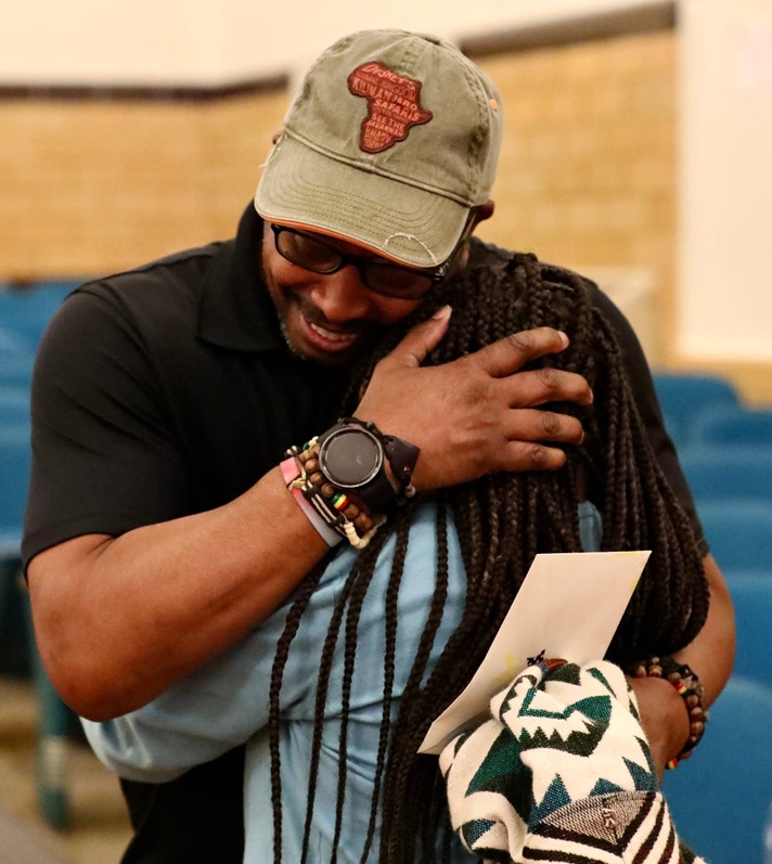 A veteran hugs a student after the ceremony