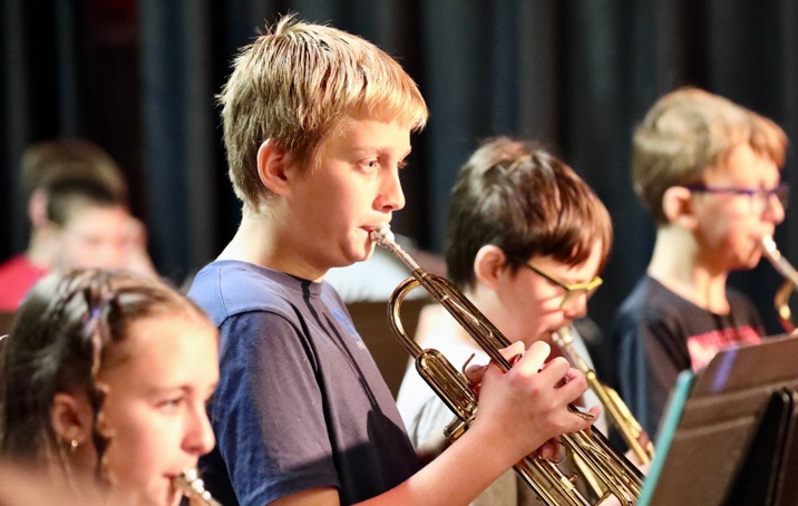 Students play musical instruments at the assembly