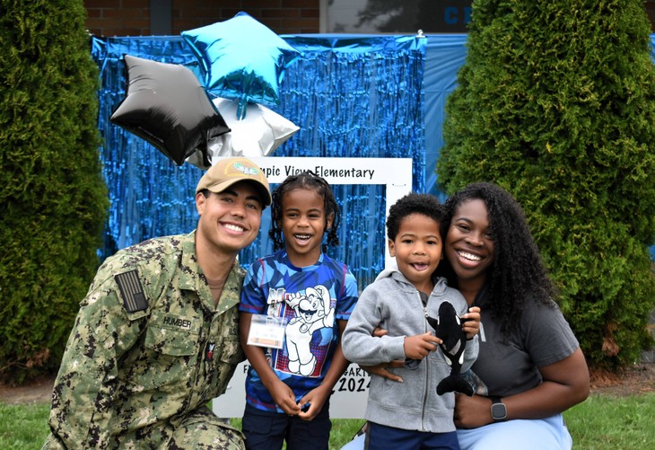 father in military uniform and mother posing with two small children at olympic view elementary