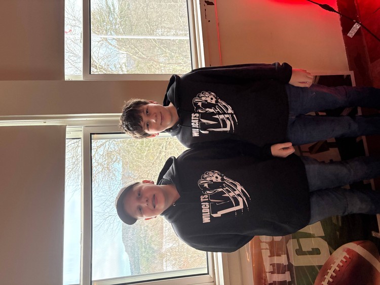 2 students wearing the art club designed sweatshirts