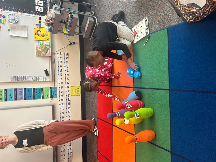 two students placing a robot to knock over bowling pins