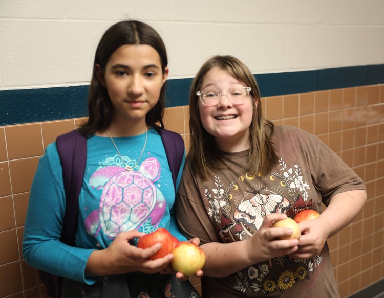 Students hold apples 