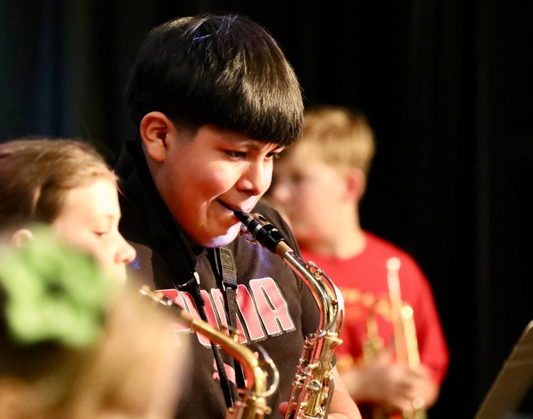 Students play musical instruments at the assembly