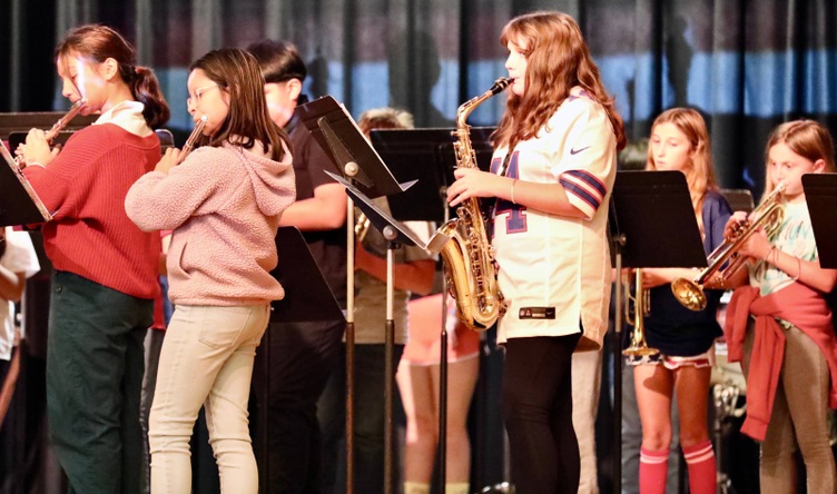 Students play musical instruments at the assembly