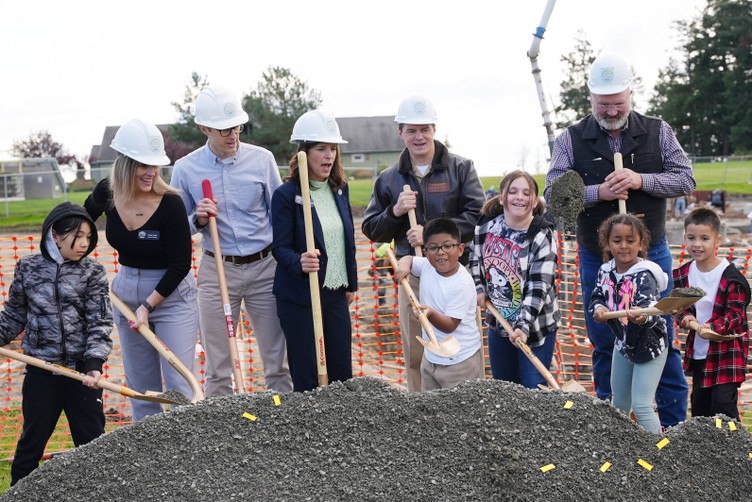 students and officials shoveling new dirt