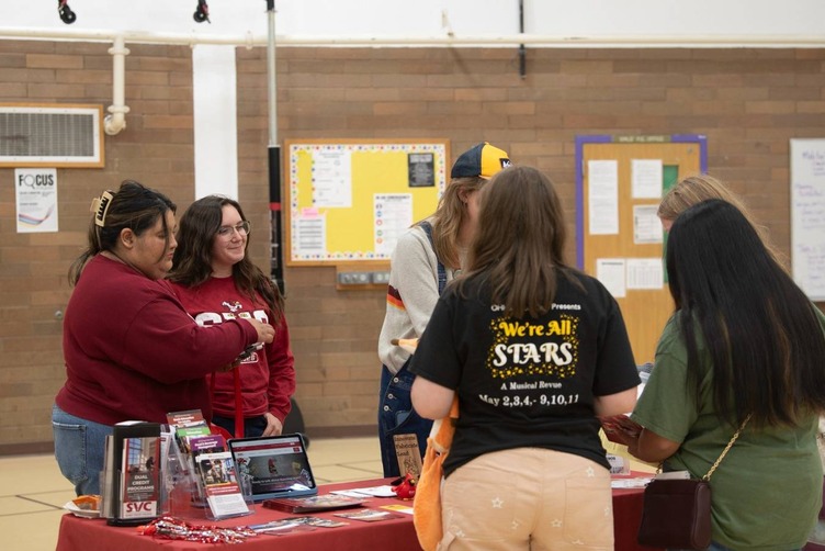 students speak with college representatives