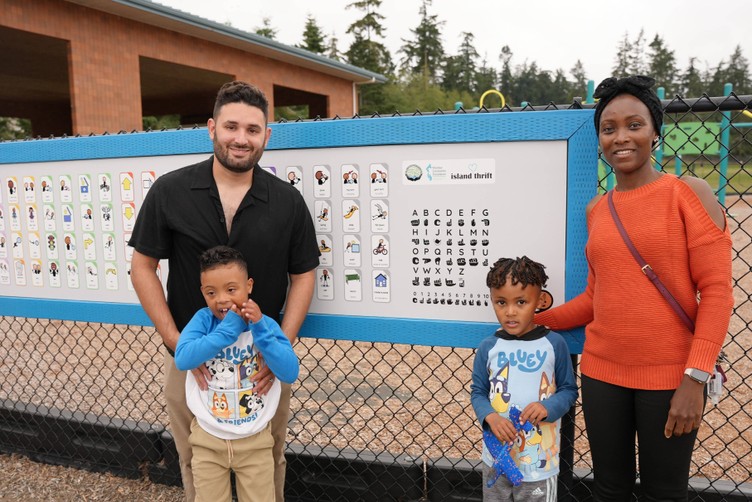 parents and two boys standing in front of playground