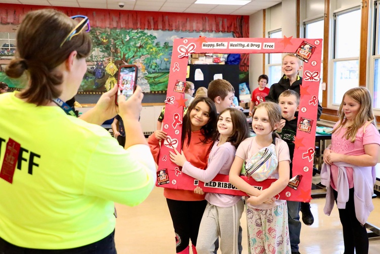 Students stand inside a picture frame for Red Ribbon Week 