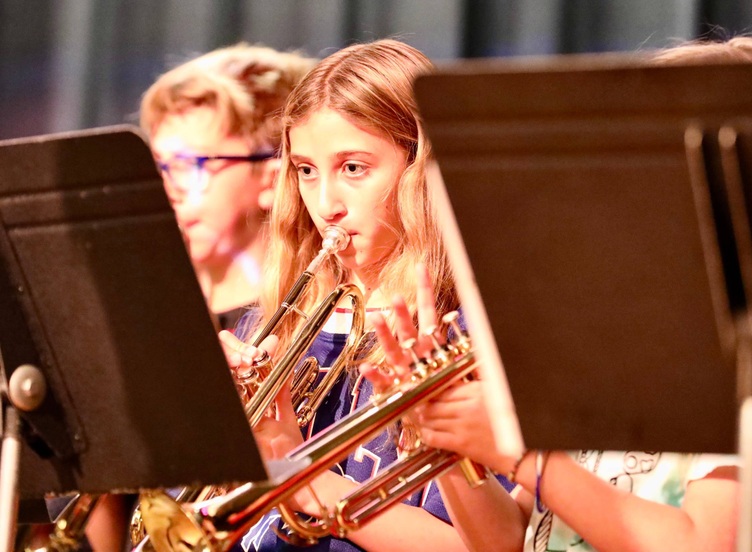 Students play musical instruments at the assembly