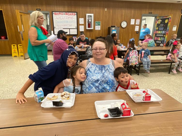 grandparent and grandchildren at breakfast table