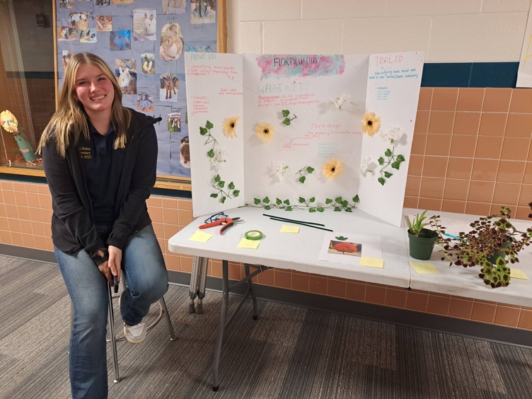 An FFA member sits by a display 