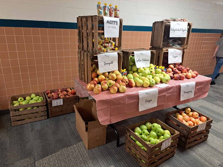 A table displays many varieties of apples and apple sauce.