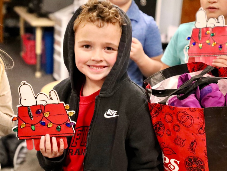 A student shows a Snoopy arts and crafts project.