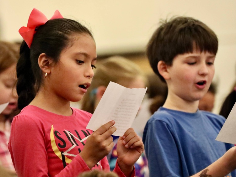 Students stand for a reading 