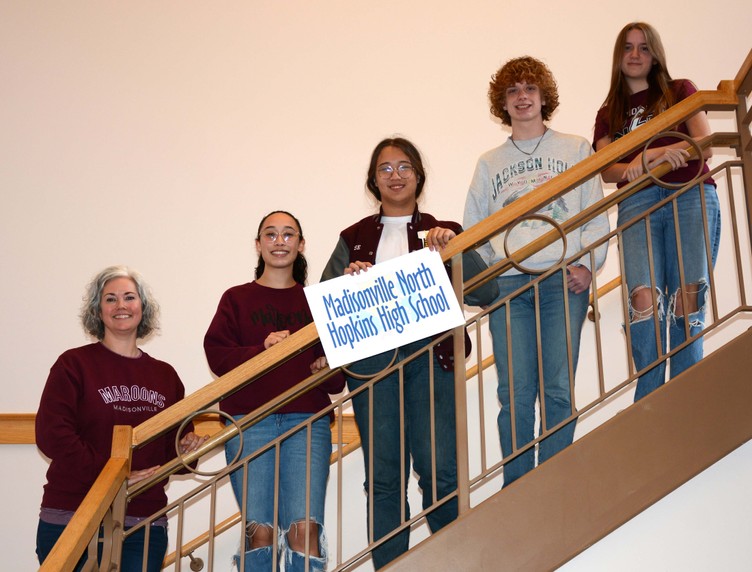 5 people stand on staircase with sign with the words Madisonville North Hopkins High School