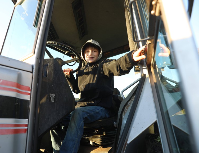 A student prepares to exit the cab of a tractor