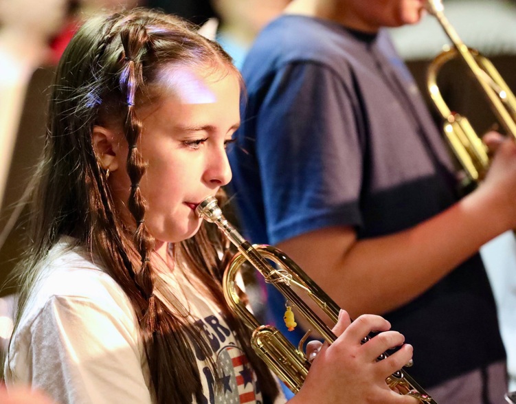 Students play musical instruments at the assembly