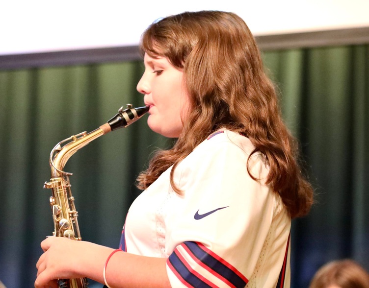 Students play musical instruments at the assembly