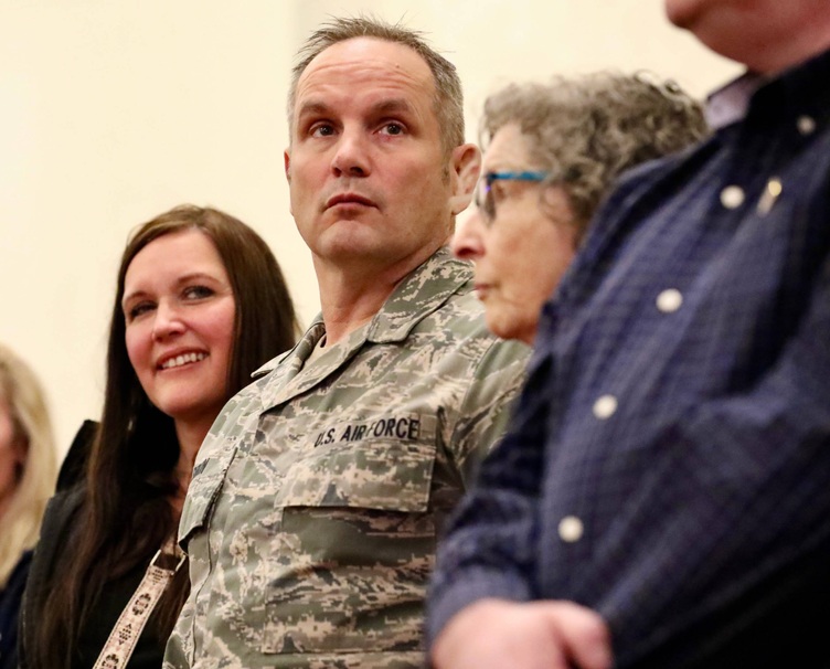 A veteran stands with his family 