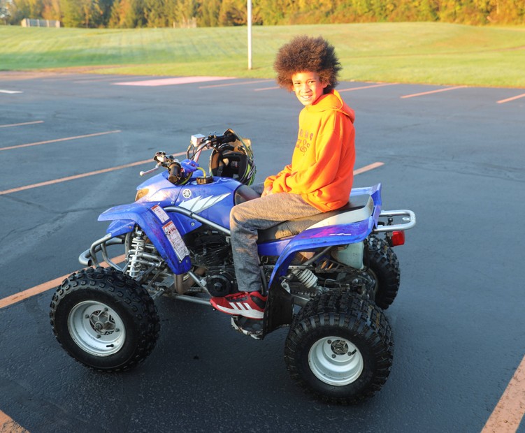 A student sits on a four-wheeler