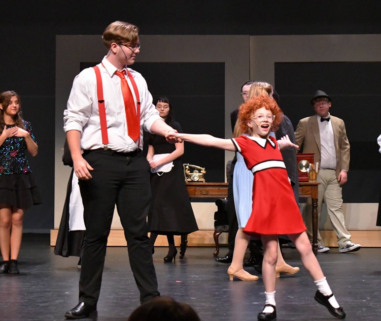 1 person dances with a girl in red dress with others in background