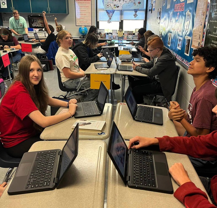 About 8 students work on laptops