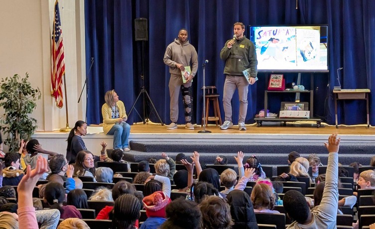 Chris Long and Joe Reed talking to Johnson students on auditorium stage