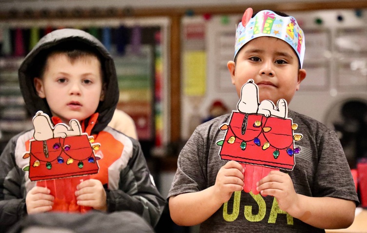 Students show their Snoopy arts and crafts projects.