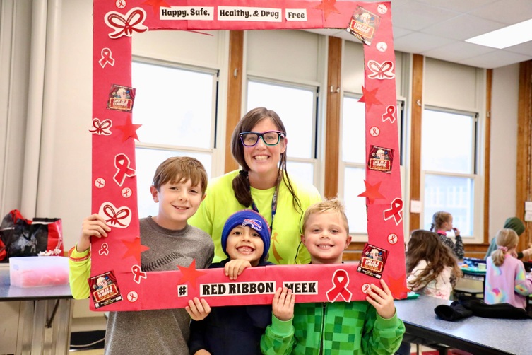 Students stand inside a picture frame for Red Ribbon Week 