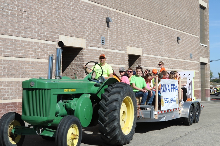 FFA Students on float pulled by green tractor