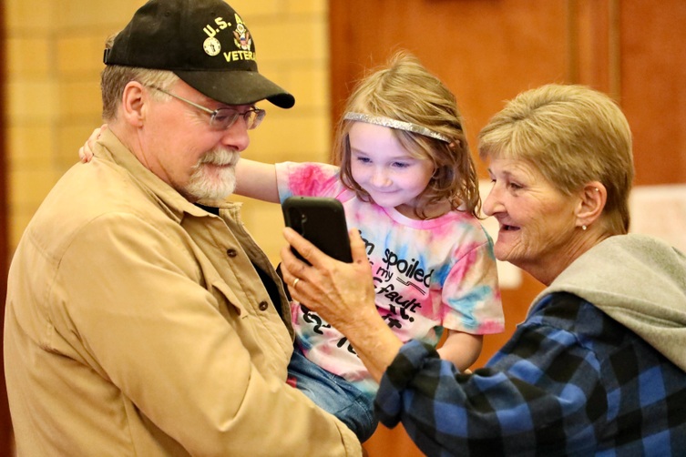 A veteran stands with a child after the ceremony