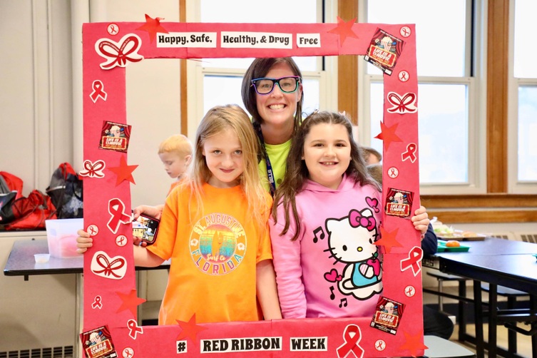 Students stand inside a picture frame for Red Ribbon Week 