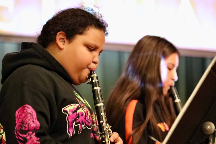 Students play musical instruments at the assembly