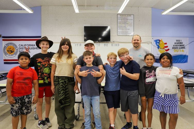 A group of Elementary students pose for a photo in their school cafeteria 