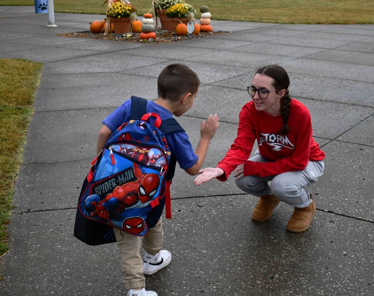 Young student gives high five to another student