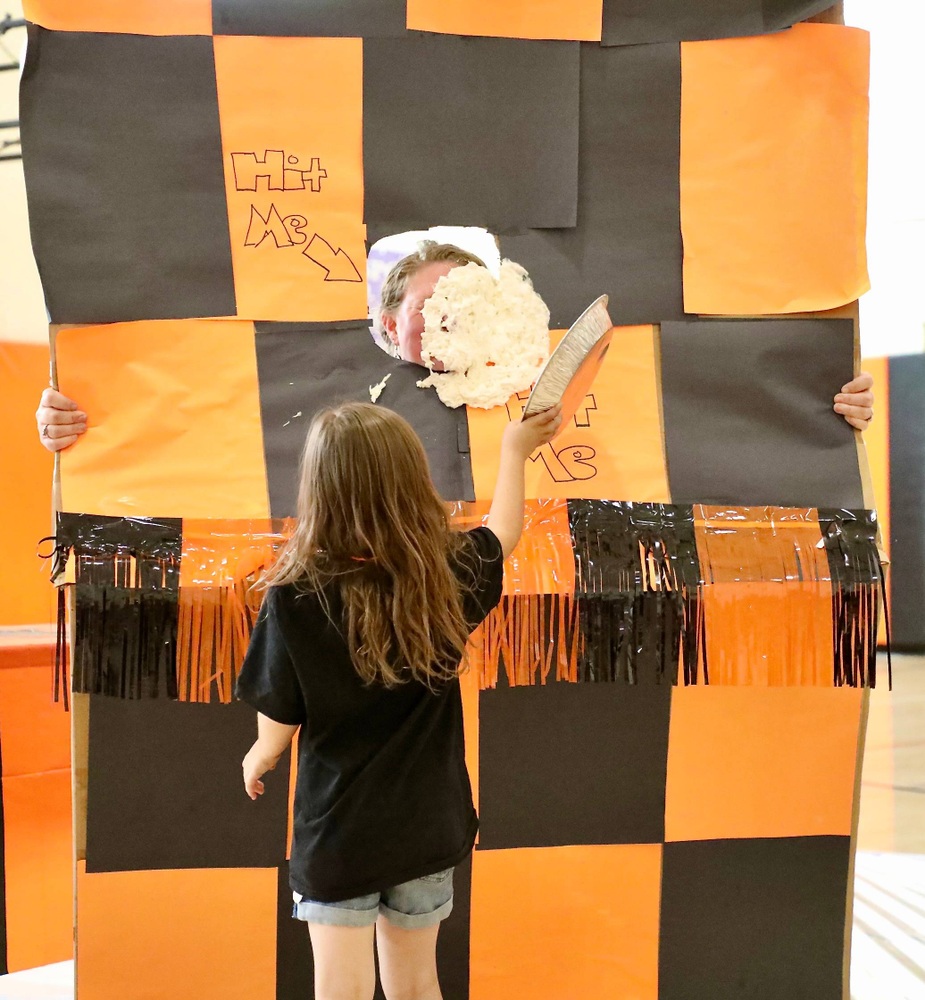 A student throws a pie at a staff member during the MES pep assembly 