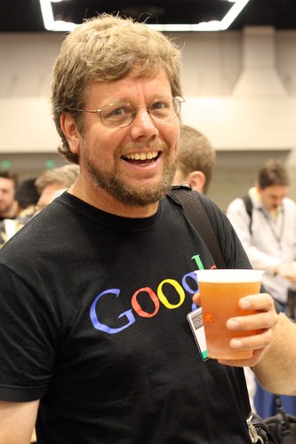 Guido Van Rossum, créateur de Python, à la OSCON 2006. Il tiens une bière dans un gobelet en plastique et fait un sourire génant - source Wikipédia