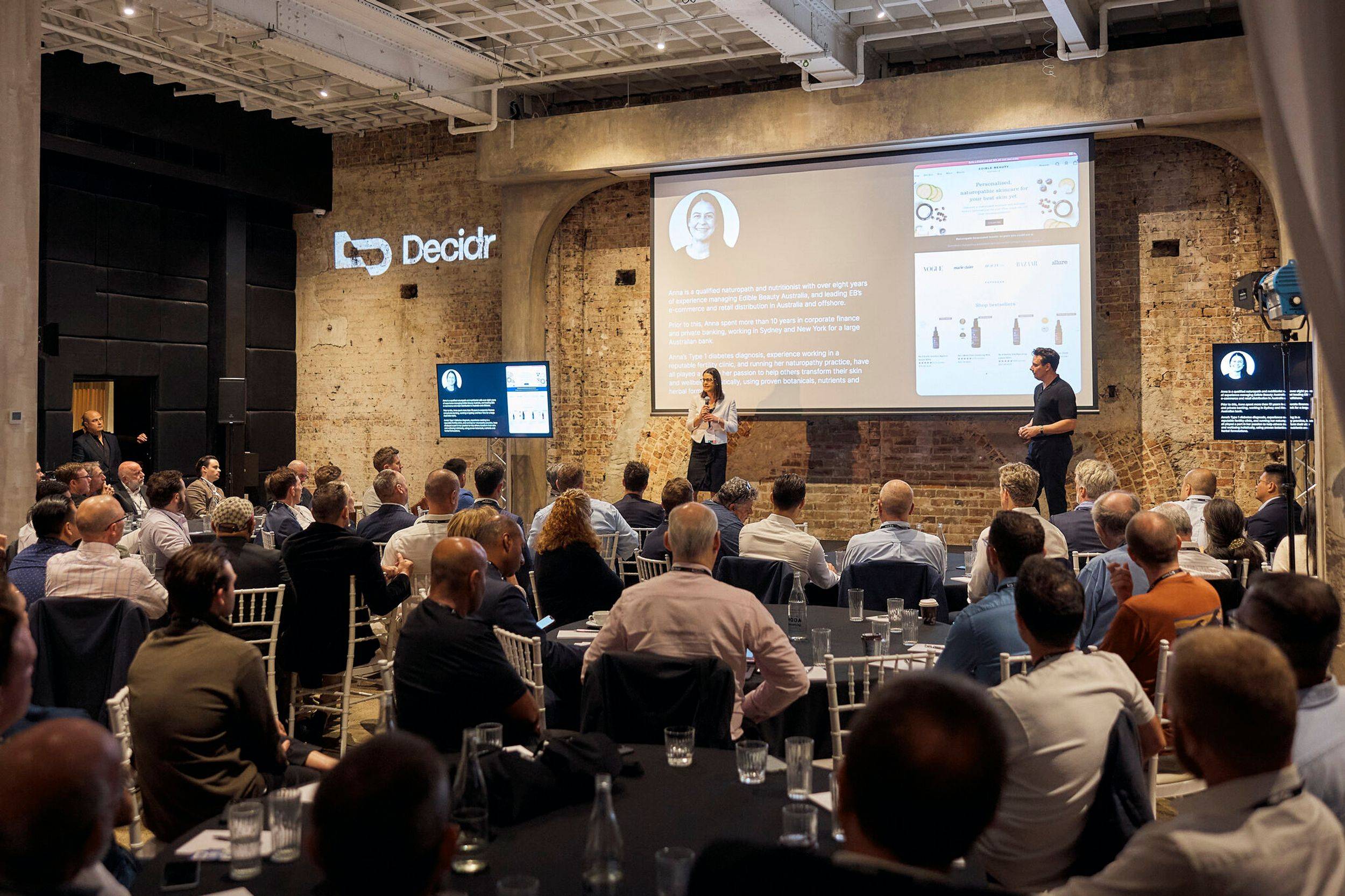 Anna Mitsos presenting at Decidr Discovery Day, accompanied by David Brudenell