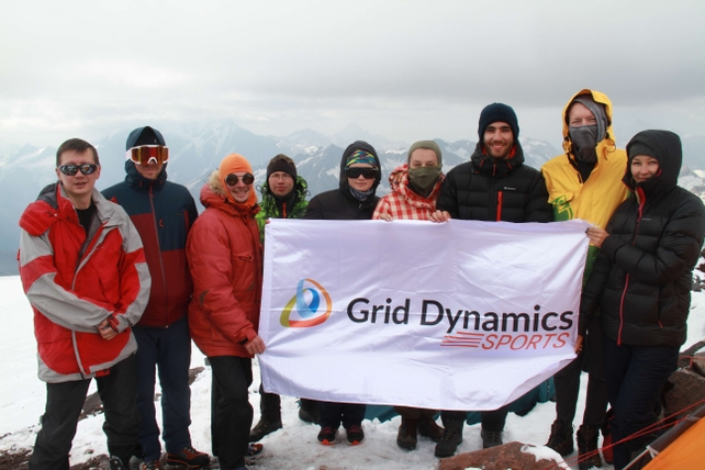 Grid Dynamics team on Elbrus with a brand flag