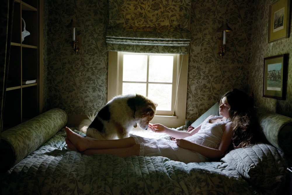 Kvinna och hund i sängen.