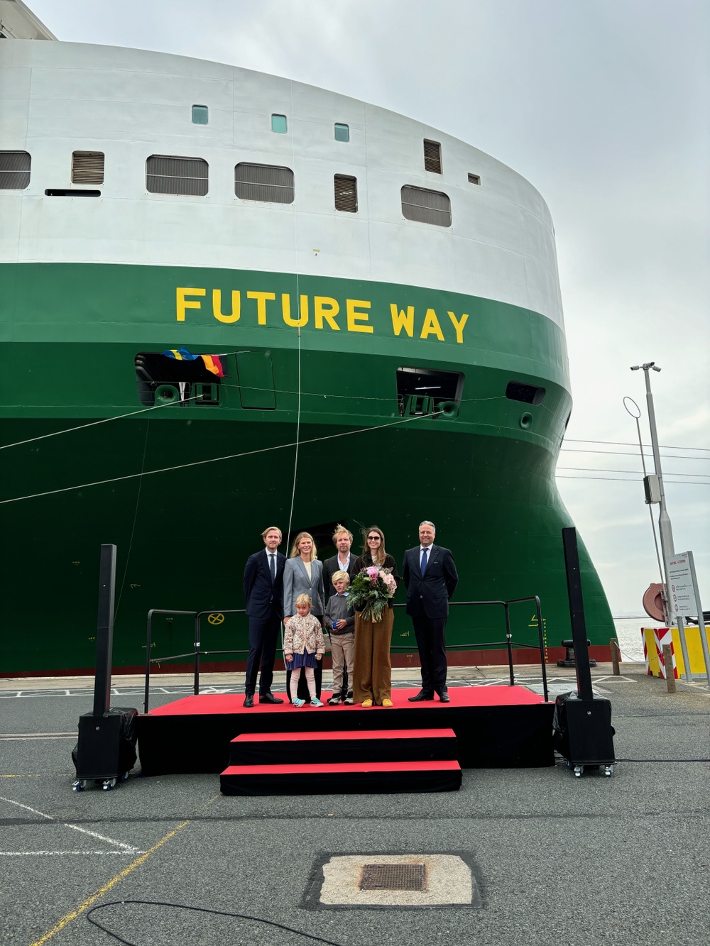 M/V Future Way's Lady Sponsor, German-born artist  
Milana Schoeller with flowers and together with her husband 
Ludvig Andersson and their children. Also on stage owner representatives and Erik Nøklebye, CEO of Wallenius Lines.

M/V Future Ways gudmor, den tyskfödda konstnären  
Milana Schoeller med blommor och tillsammans med sin man 
Ludvig Andersson och deras barn. På scenen även ägarrepresentanter och Erik Nøklebye, VD för Wallenius Lines.