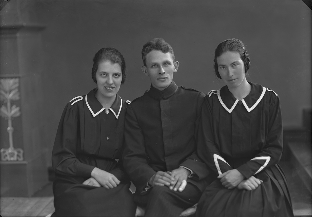Porträtt av två kvinnor klädda i klänningsuniformer och man klädd i militär uniform. Foto: Ida Ekelund, ur Kulturens samlingar. 