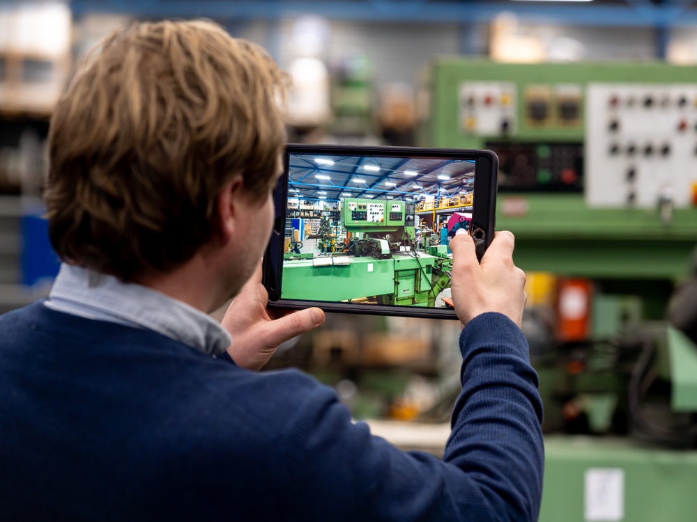 Industrial Technology: an employee uses a tablet during the sales process of metalworking machinery.