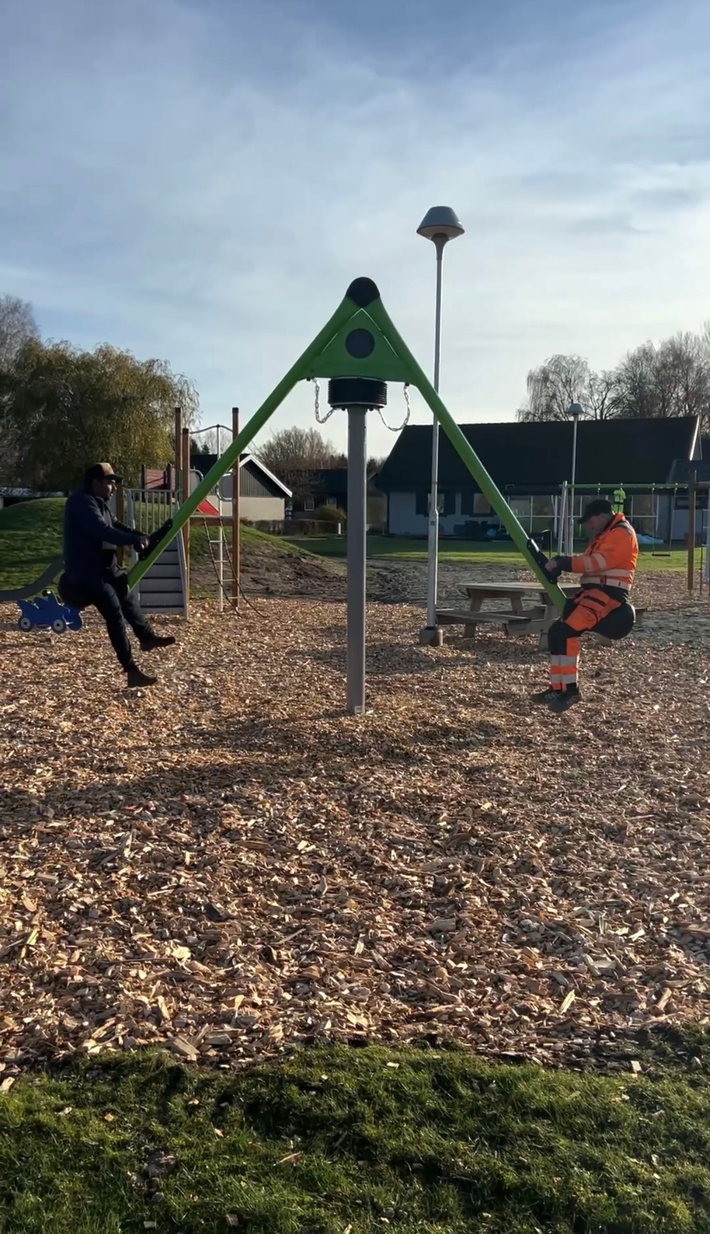 KS ordförande Daniel Andersson och Eric Nyblom som är medarbetare på gata/park testar den nya vippgungan på lekplatsen.