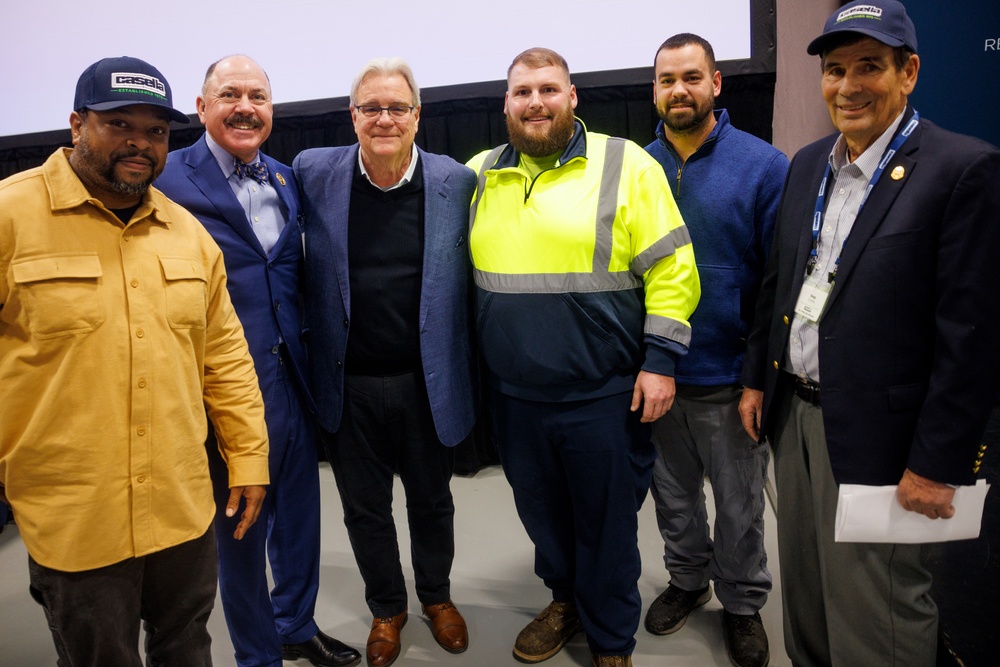 John Casella, Chairman & CEO of Casella Waste Systems, Inc., and Doug Casella, Founder of Casella Waste Systems, Inc., pose with current students at the dedication of the Kenneth A. Hier Sr. CDL Training Center.