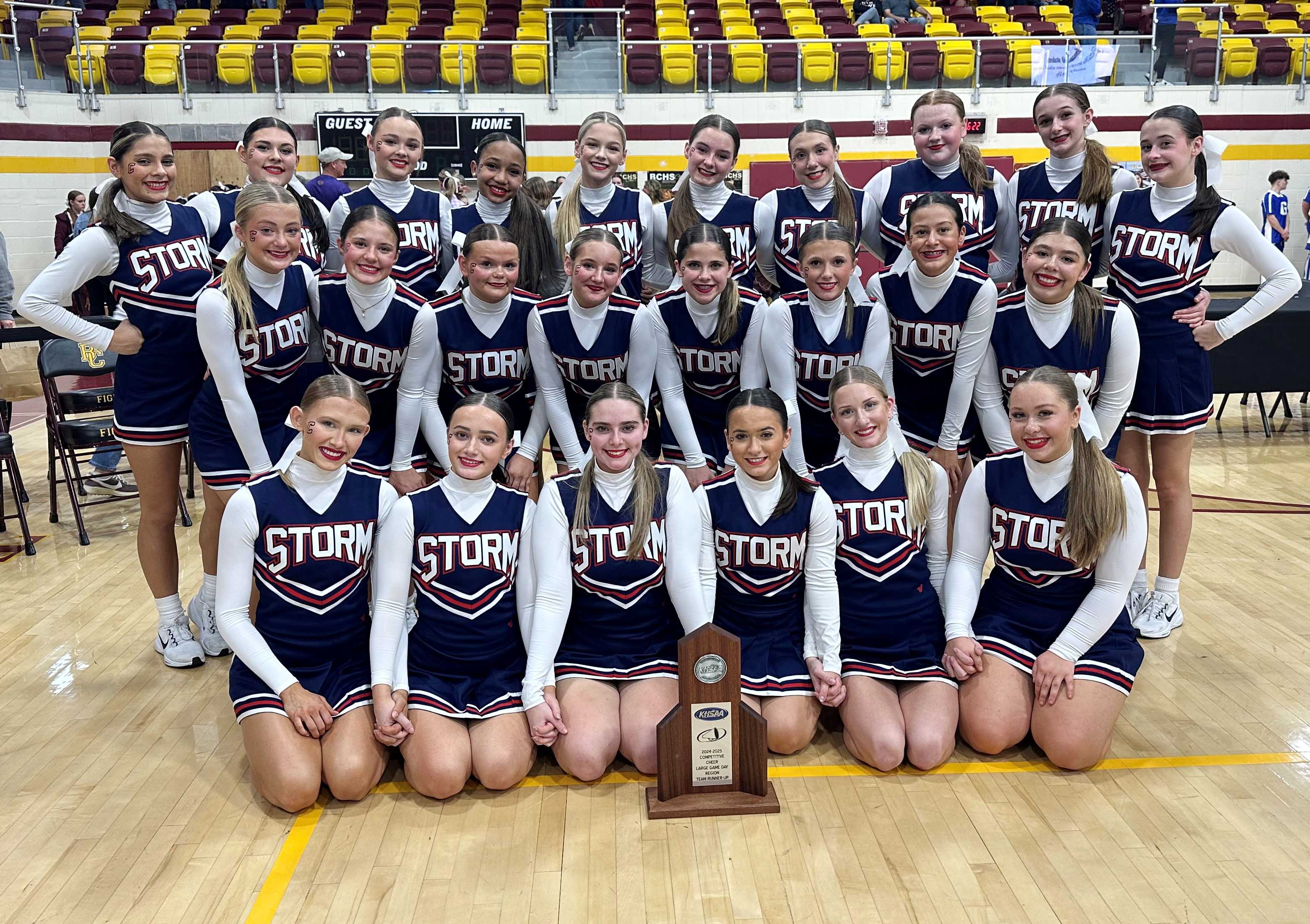 Cheer team in navy and white uniforms with the word "storm" on the front.